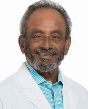 A man with a beard and mustache wearing a white coat.